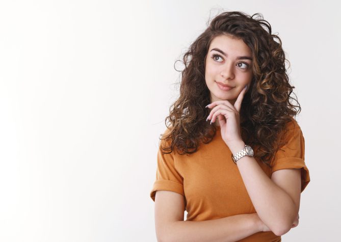 Cute dreamy girl deciding what product better look up thoughtful touch chin thinking smiling shopping alone, standing white background making choice considering proposals, white background.