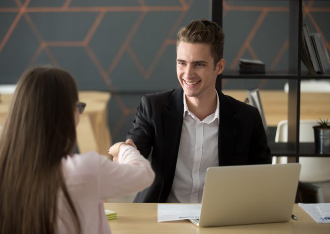 Smiling hr manager handshaking successful applicant hiring or greeting, friendly satisfied employer offering job contract shaking hand of winning candidate at interview, employment recruiting concept